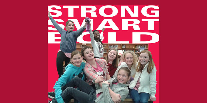 eight girls posing enthusiastically with the words strong, smart, bold in the background