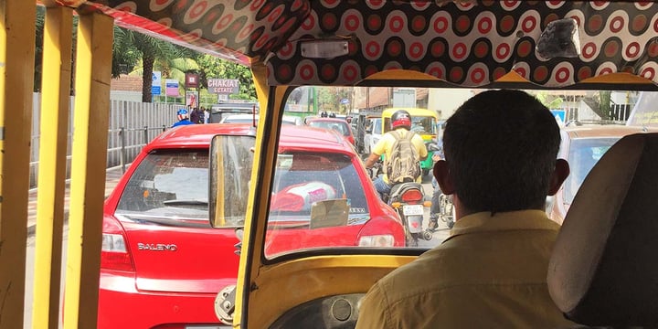 looking over the shoulder of a transit driver in India onto a street jammed with traffic