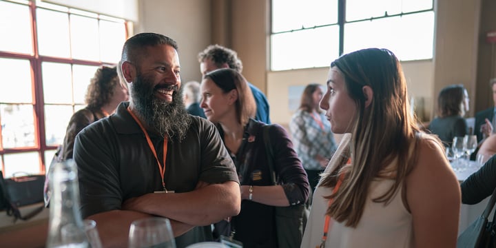 people laughing and talking at a networking event over drinks 