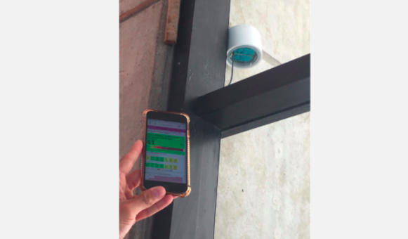 smartphone held near an air quality sensor