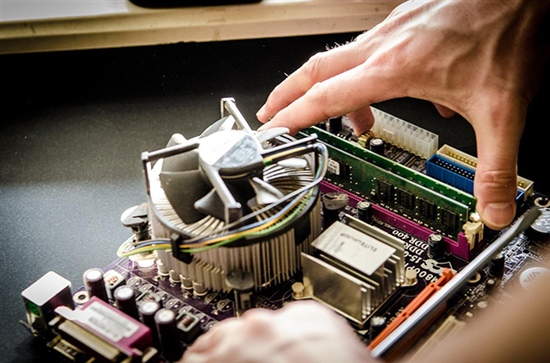 person's hands shown repairing a computer circuit board