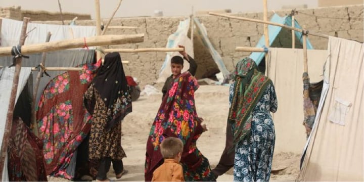 Women walk among makeshift tents in a camp for internally displaced people in Mazar-e Sharif city in northern Afghanistan