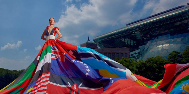 model standing in front of Seoul city hall wearing the rainbow dress just described