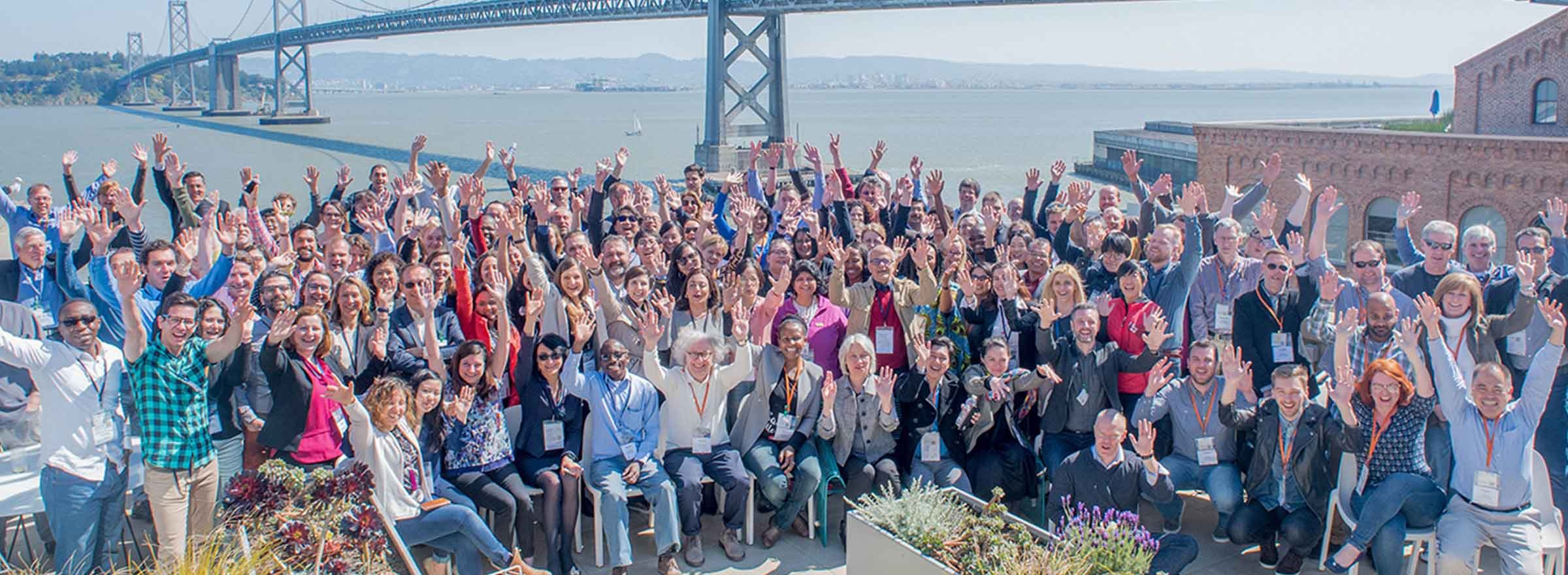 techsoup staff celebrating together in front of the bay bridge, representing the opportunity to invest in techsoup to build a more equitable planet