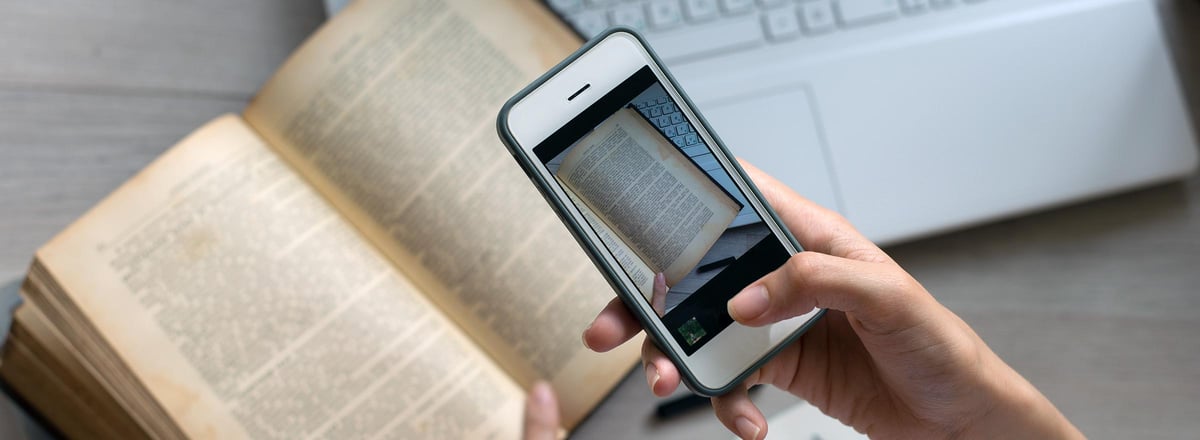 hand using a smartphone to make an image of a printed book