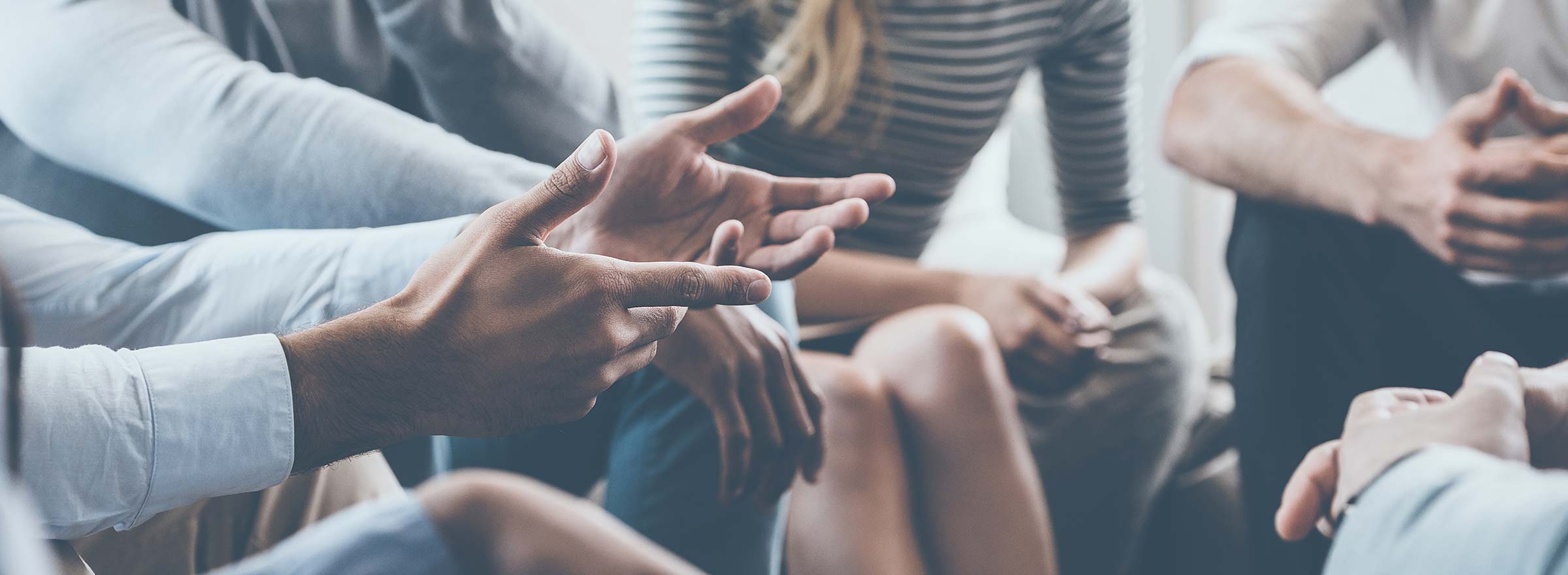 hands of people sitting in a tight group