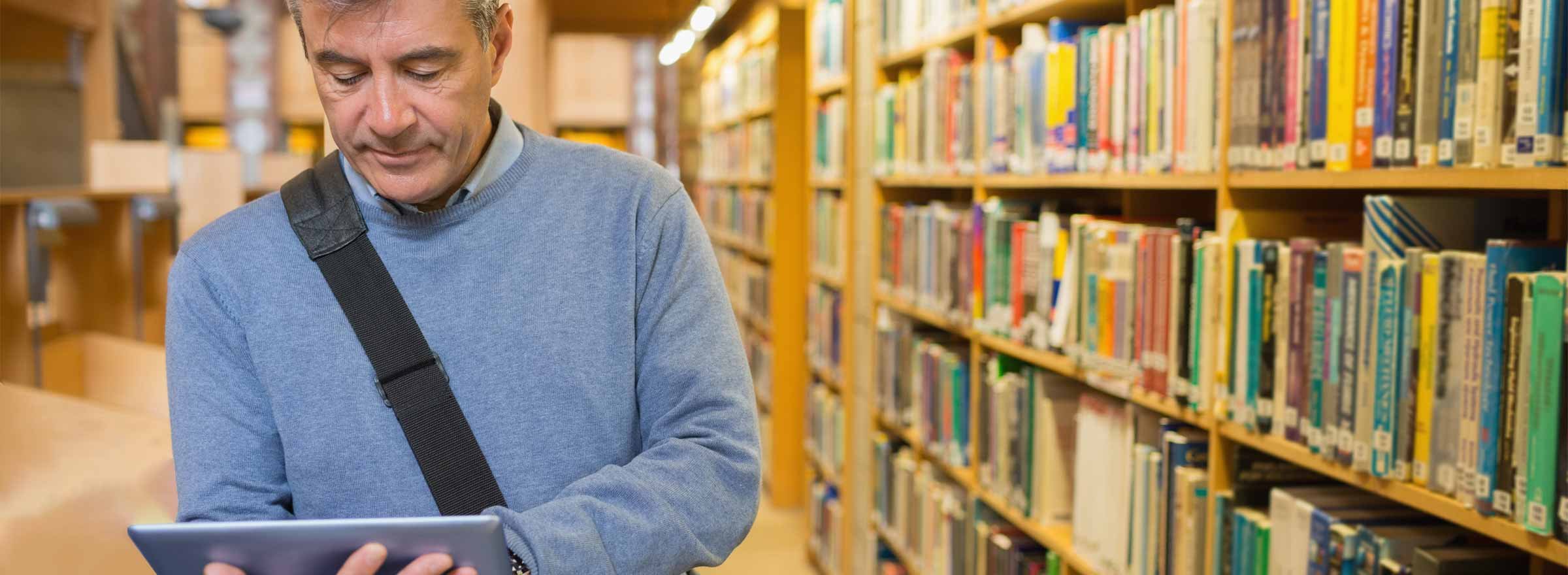 man using a tablet in a library
