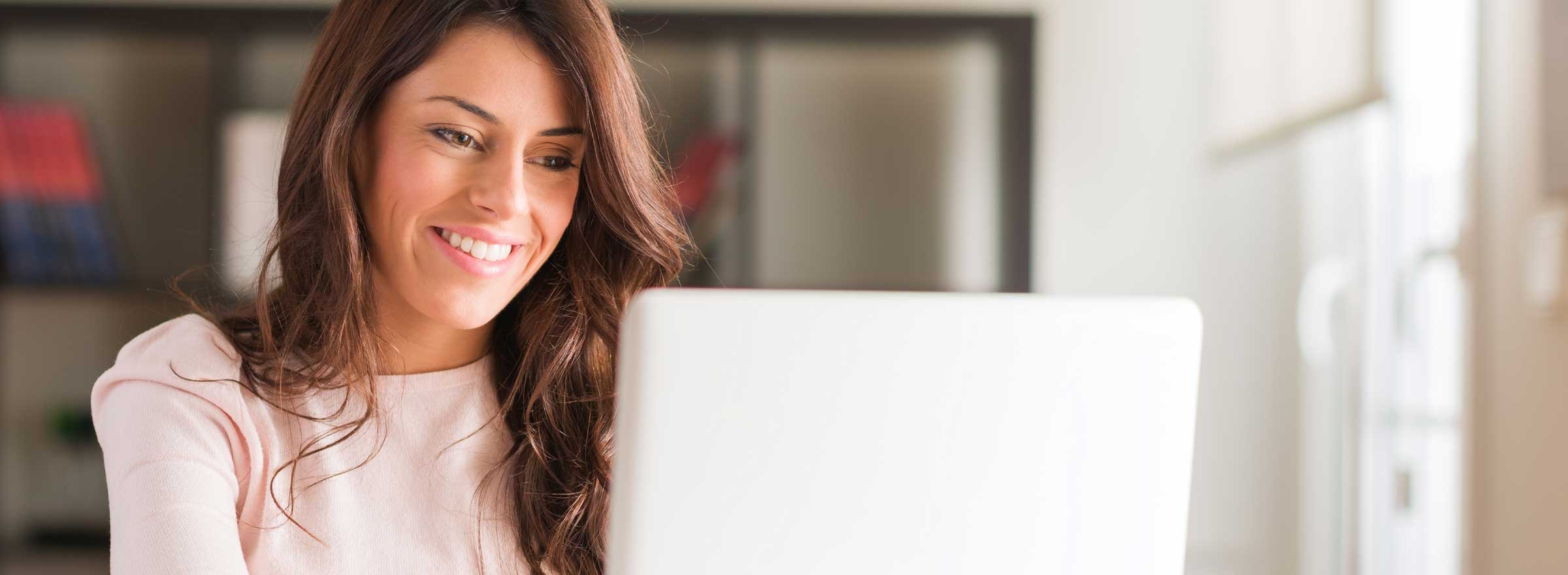 woman smiling at laptop screeen
