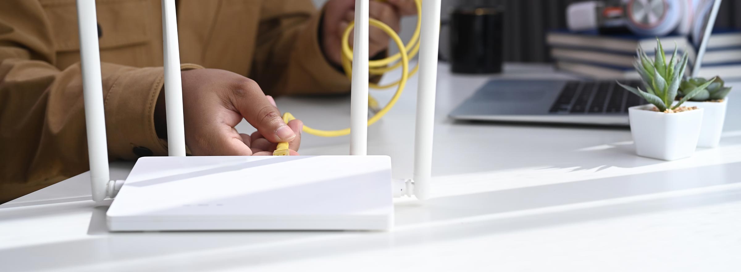 hand of someone attaching a cable to a router