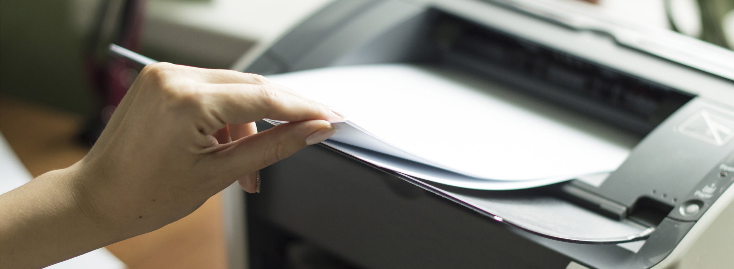 hand removing pages from a printer
