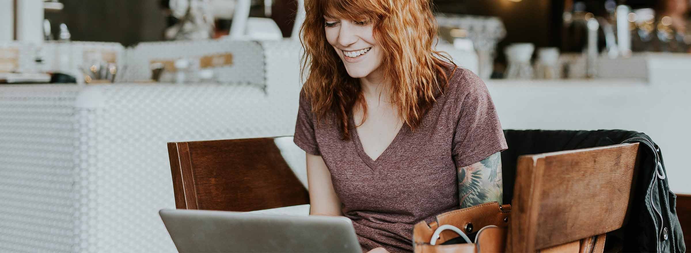 woman smiling at a laptop screen