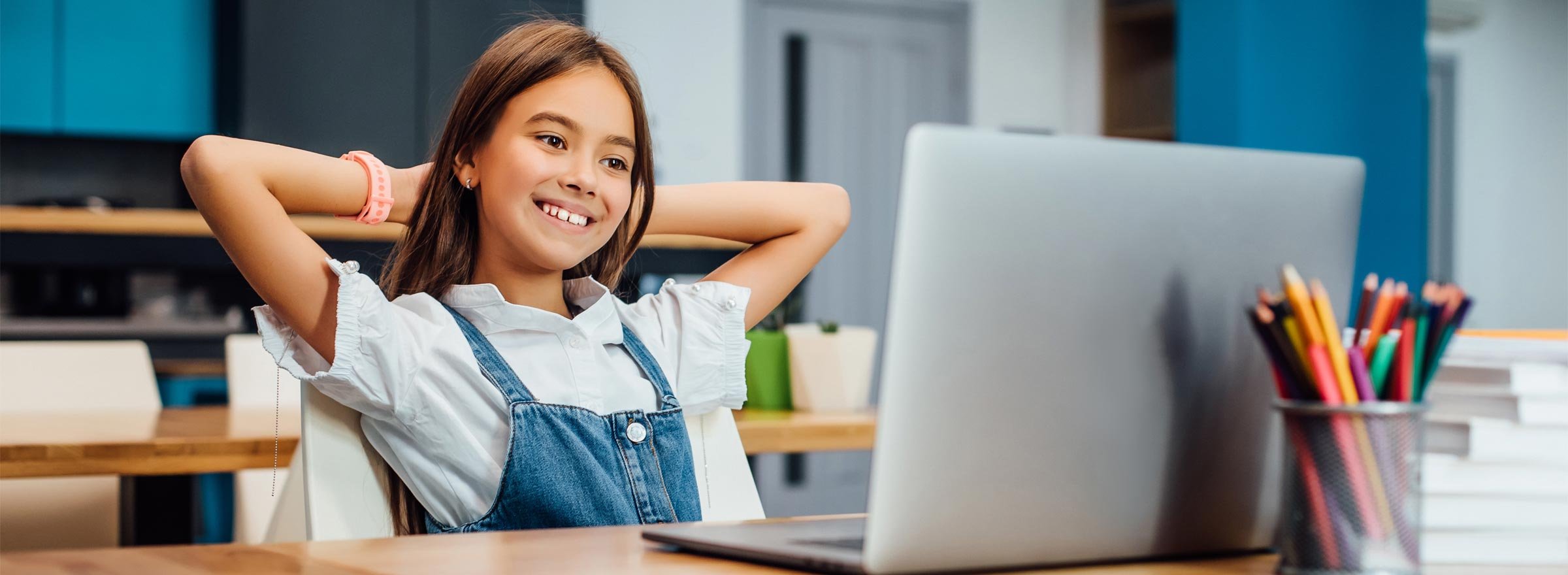 girl leaning back and smiling at a computer screen