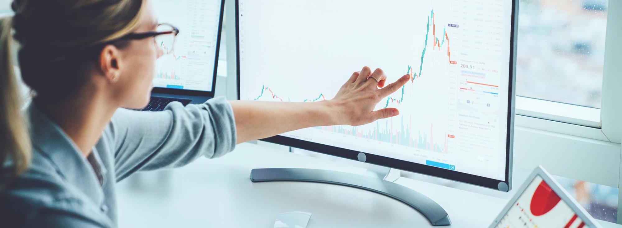 woman pointing to a graph on a monitor