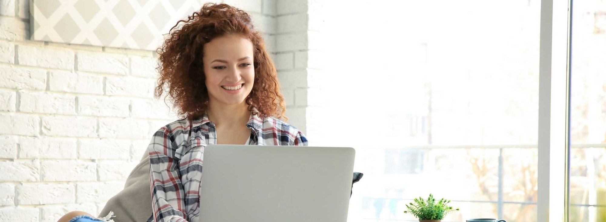 woman smiling at a computer screen