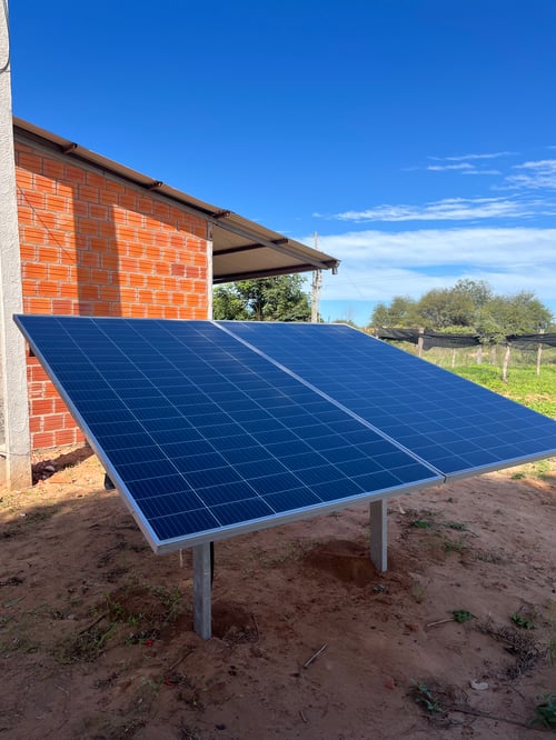 Photo of a solar panel installation outside a brick building on a sunny day.